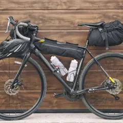 Vélo prêt pour le bikepacking, équipé de sacoches, gourdes et casque. L'aventure vous attend !