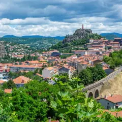 Vue panoramique de la ville avec ses églises perchées sur des pitons rocheux, un aperçu des incontournables autour du Puy-en-Velay.