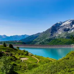 Paysage de montagne spectaculaire avec un lac turquoise et un barrage. Un endroit à voir en Auvergne pour sa beauté naturelle.