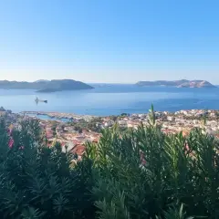 Vue panoramique sur la mer Égée, avec une ville côtière et des îles au loin. Un aperçu de la **voie lycienne**.