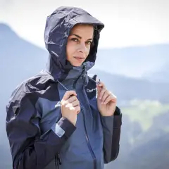 Femme en veste à capuche, prête pour la pluie. Comprendre la différence entre étanche et imperméable est essentiel pour choisir la bonne protection.