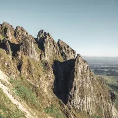 Le cirque de la fontaine salée, un paysage de montagnes escarpées et verdoyantes sous un ciel clair.