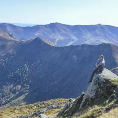 Un homme contemple les paysages grandioses du Cantal, un aperçu de ce que réservent les plus belles randonnées dans le Cantal.