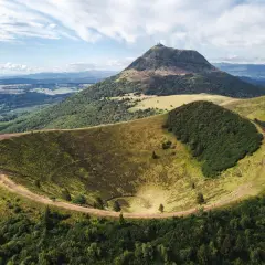 Vue aérienne du cratère du Pariou, un volcan endormi en Auvergne, avec le Puy de Dôme en arrière-plan.