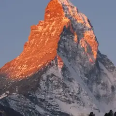 Le Mont Cervin, baigné de soleil couchant, révèle sa beauté majestueuse. Sa silhouette imposante et ses pentes enneigées témoignent de sa difficulté légendaire.