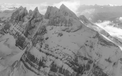 Majestueuses **Dents du Midi** enneigées, leurs sommets acérés percent les nuages dans un paysage alpin spectaculaire.