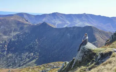 Un homme contemple les paysages grandioses du Cantal, un aperçu de ce que réservent les plus belles randonnées dans le Cantal.