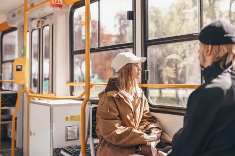 Dans un train, une jeune femme au bonnet blanc regarde par la fenêtre. Le paysage défile, rappelant un voyage en Cantal.