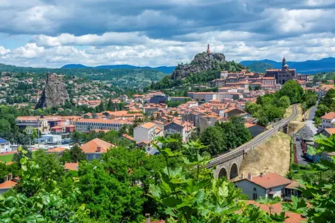 Vue panoramique de la ville avec ses églises perchées sur des pitons rocheux, un aperçu des incontournables autour du Puy-en-Velay.