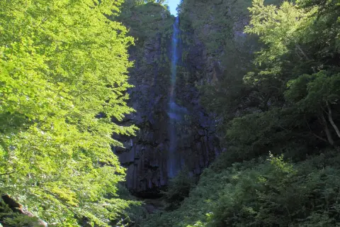 Randonnée dans la vallée de Chaudefour, la cascade de la Biche se dévoile à travers une végétation luxuriante et verdoyante.