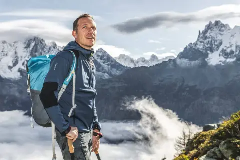 Randonneur avec sac à dos bleu, prêt pour 5 jours d'aventure. Le poids du sac à dos est optimisé pour la randonnée.