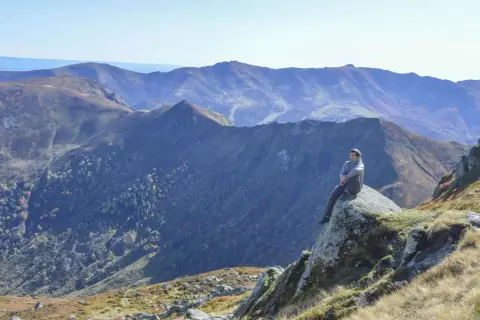 Un homme contemple les paysages grandioses du Cantal, un aperçu de ce que réservent les plus belles randonnées dans le Cantal.