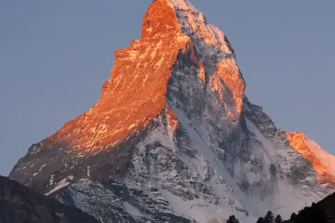 Le Mont Cervin, baigné de soleil couchant, révèle sa beauté majestueuse. Sa silhouette imposante et ses pentes enneigées témoignent de sa difficulté légendaire.