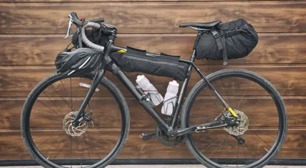 Vélo prêt pour le bikepacking, équipé de sacoches, gourdes et casque. L'aventure vous attend !