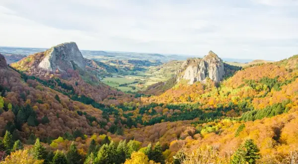 Paysage d'automne en Auvergne, avec des volcans et des forêts aux couleurs vives. Idéal pour savoir où aller en Auvergne l'été, mais magnifique aussi en automne.