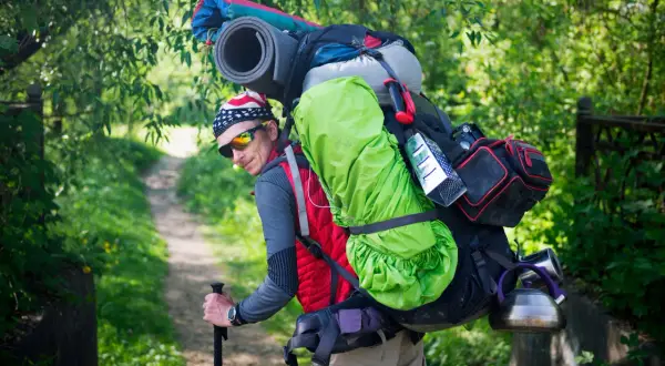 Randonneur avec un sac de trek chargé, prêt à affronter le poids de son aventure.