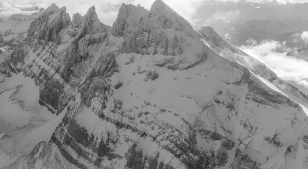 Majestueuses **Dents du Midi** enneigées, leurs sommets acérés percent les nuages dans un paysage alpin spectaculaire.