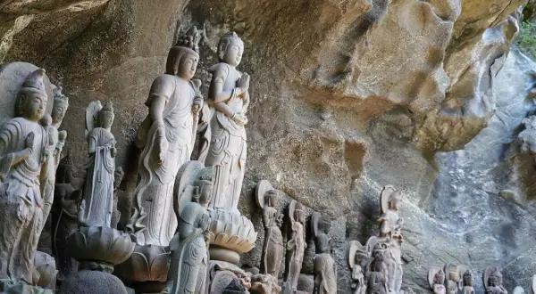 Statues de Bouddha sculptées dans la roche du mont Nokogiri, formant une procession sacrée.