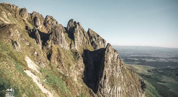 Le cirque de la fontaine salée, un paysage de montagnes escarpées et verdoyantes sous un ciel clair.