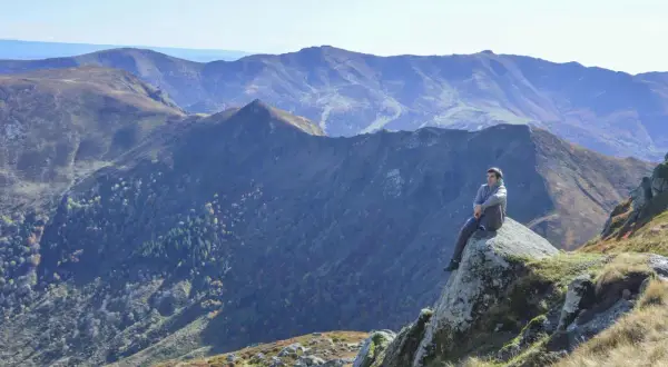 Un homme contemple les paysages grandioses du Cantal, un aperçu de ce que réservent les plus belles randonnées dans le Cantal.