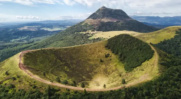 Vue aérienne du cratère du Pariou, un volcan endormi en Auvergne, avec le Puy de Dôme en arrière-plan.