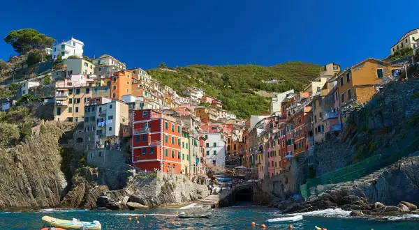 Vue colorée de Riomaggiore, un village des Cinque Terre, parfait pour un séjour de 3 jours. Bateaux dans l'eau bleue.