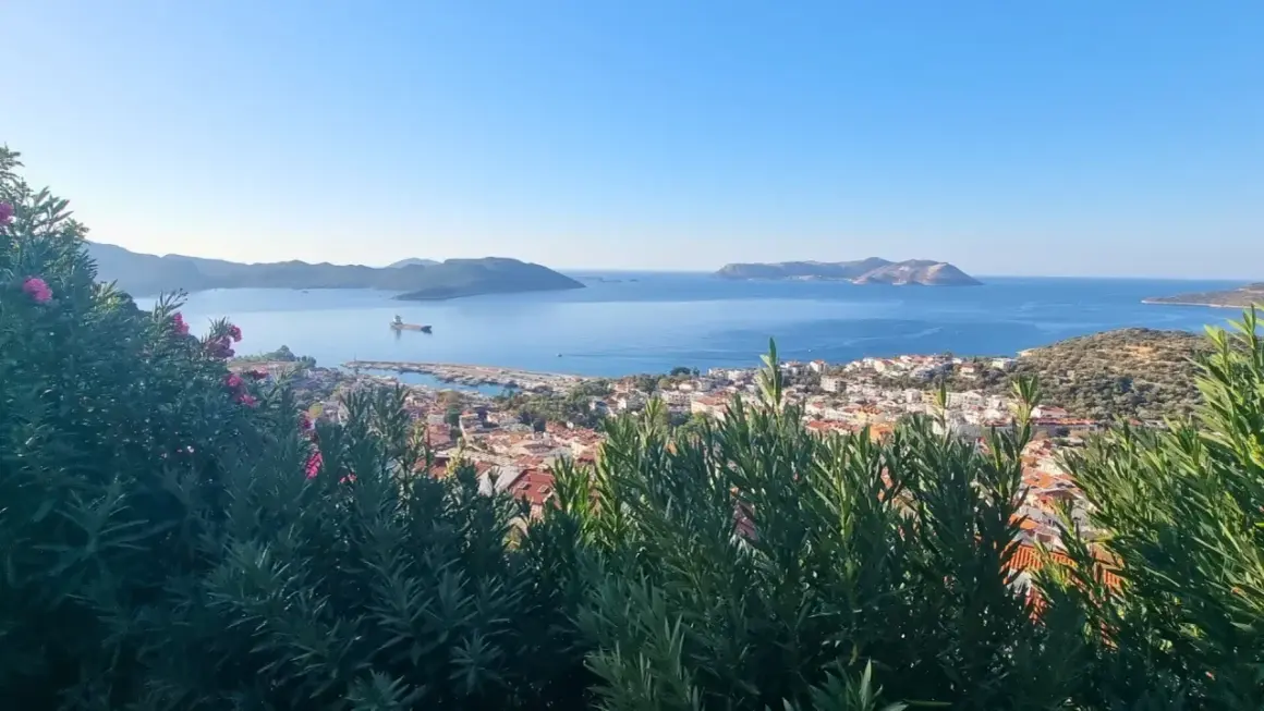 Vue panoramique sur la mer Égée, avec une ville côtière et des îles au loin. Un aperçu de la **voie lycienne**.