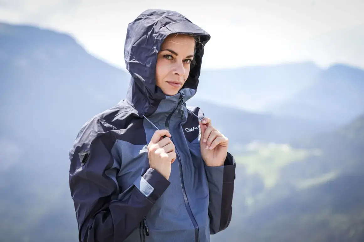 Femme en veste à capuche, prête pour la pluie. Comprendre la différence entre étanche et imperméable est essentiel pour choisir la bonne protection.