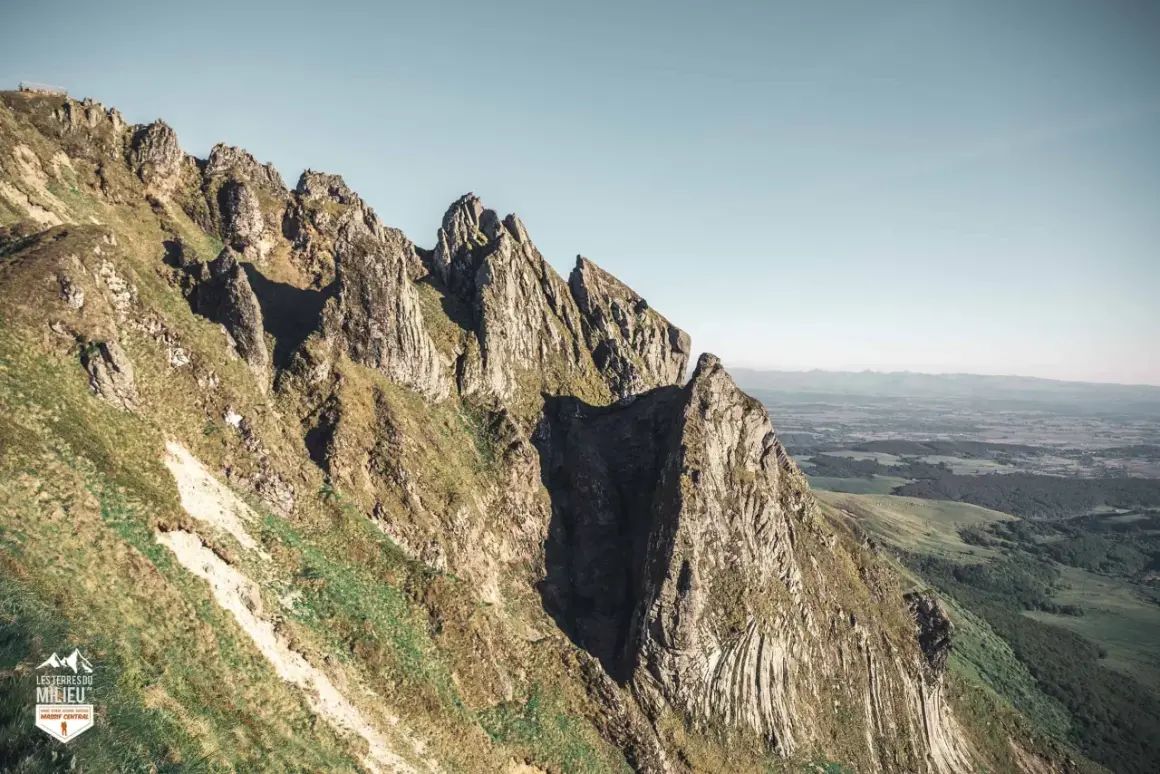 Le cirque de la fontaine salée, un paysage de montagnes escarpées et verdoyantes sous un ciel clair.