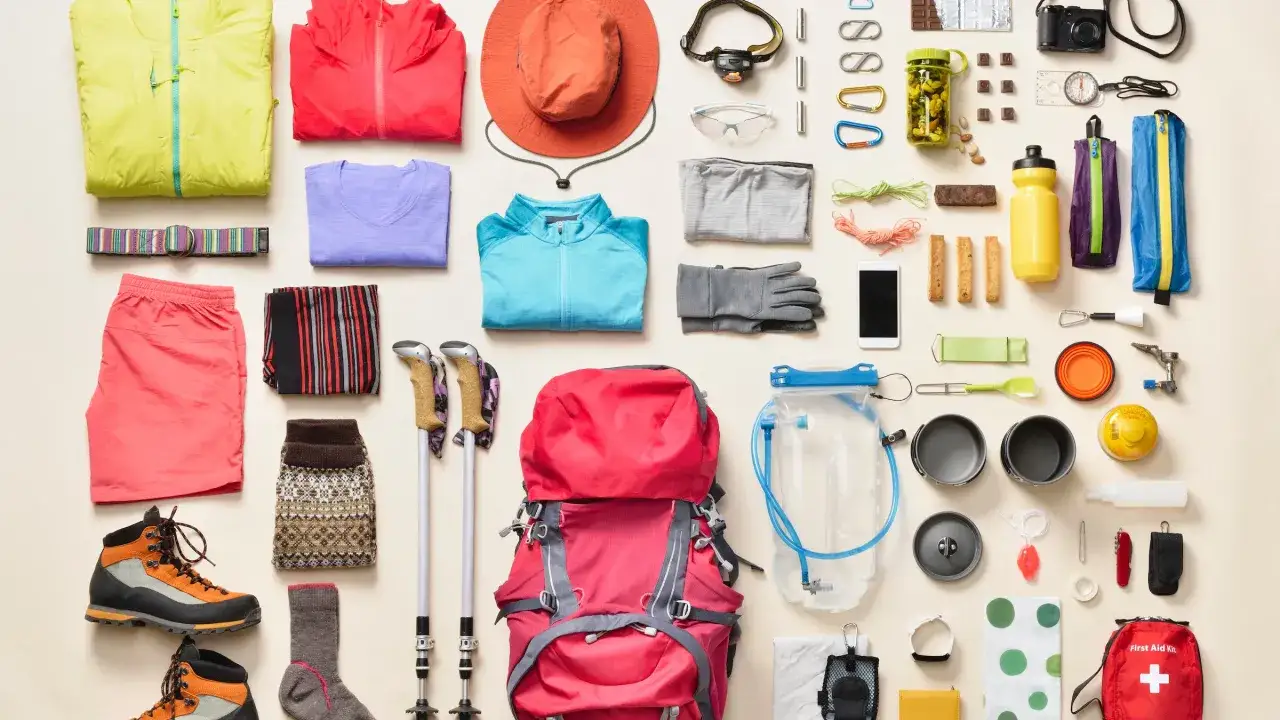 Vêtements, chaussures, sac à dos, bâtons de marche, gourde, trousse de premiers secours... tout est prêt pour se préparer pour une randonnée de plusieurs jours.