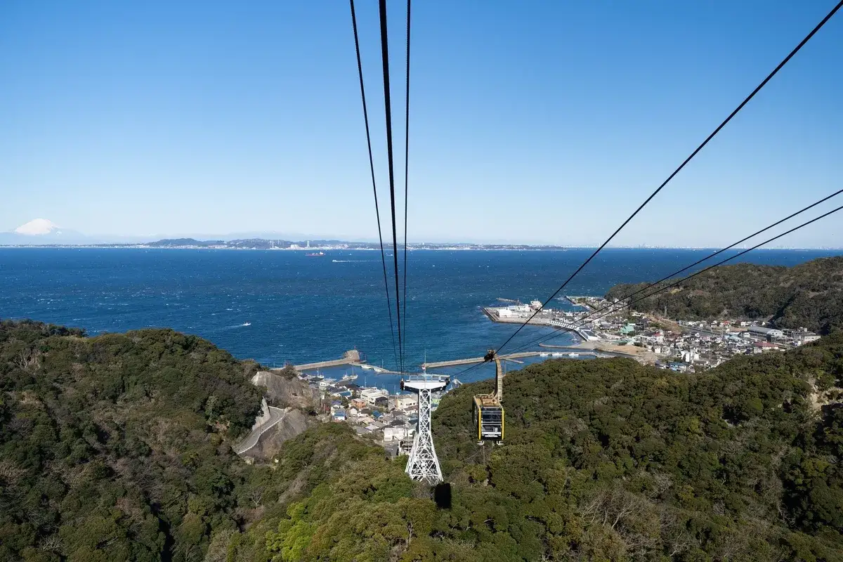 Vue depuis le t&eacute;l&eacute;ph&eacute;rique sur la baie, avec le mont Nokogiri verdoyant et le mont Fuji au loin.