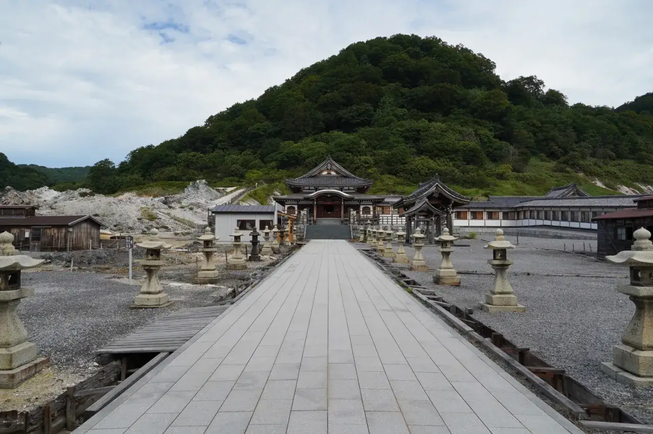 All&eacute;e de lanternes menant &agrave; un temple au pied du mont Osore, paysage min&eacute;ral et verdoyant.