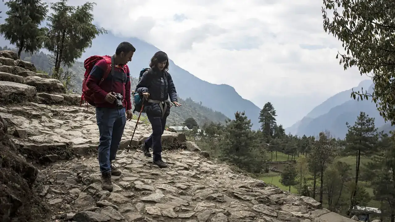 Deux randonneurs sur un sentier rocailleux. Les b&acirc;tons de marche servent &agrave; soulager les genoux et &agrave; am&eacute;liorer l'&eacute;quilibre en montagne.