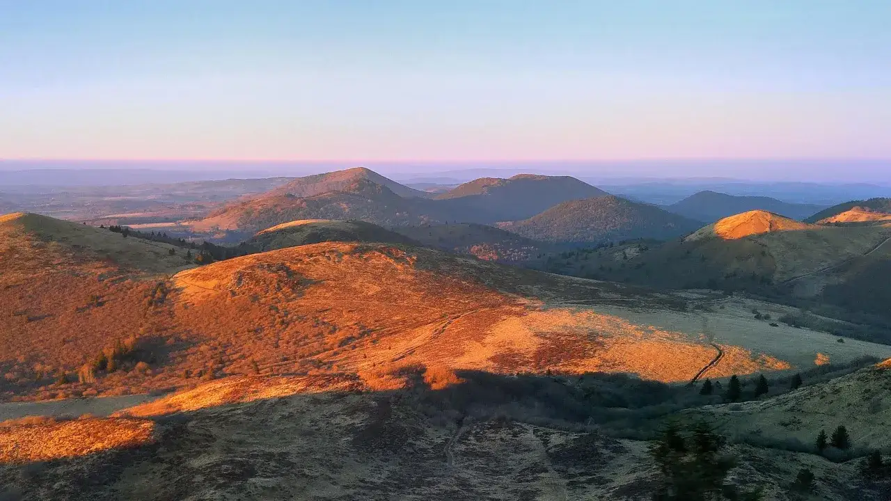 Coucher de soleil doré sur les volcans d'Auvergne, un spectacle parmi les plus beaux endroits d'Auvergne.