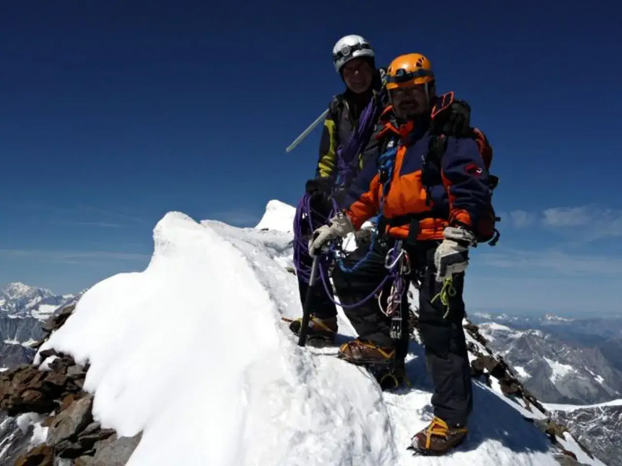Deux alpinistes sur le sommet du Mont-Cervin, une ascension &agrave; la difficult&eacute; reconnue. Le ciel est bleu, le paysage montagneux est spectaculaire.