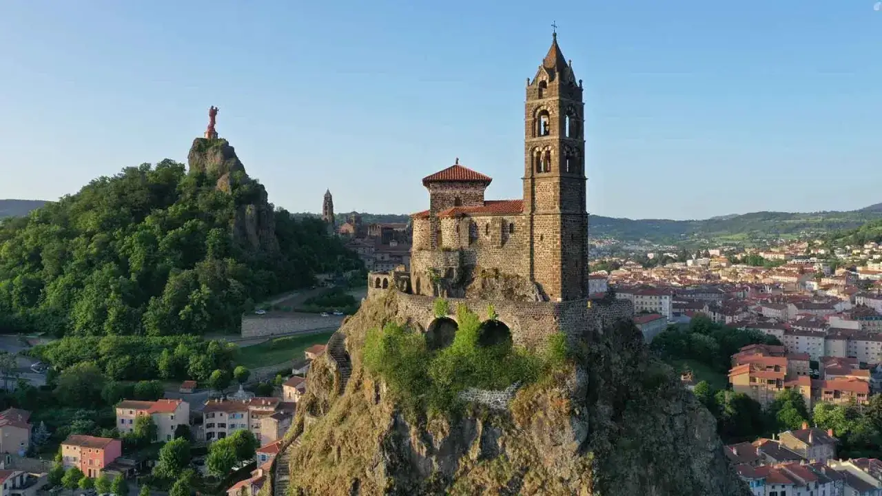 Que voir au Puy-en-Velay : la cath&eacute;drale Notre-Dame et la statue de Notre-Dame de France perch&eacute;es sur des pitons rocheux, dominant la ville.