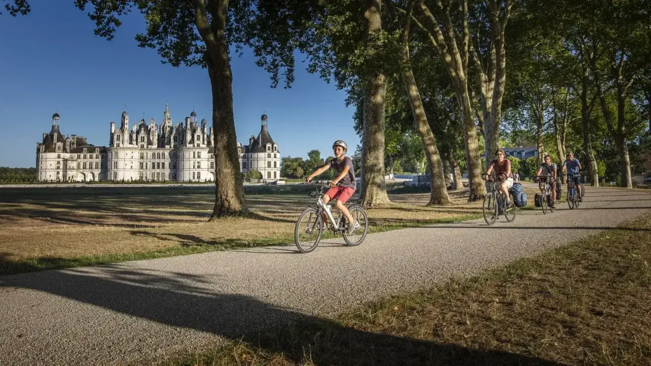Famille &agrave; v&eacute;lo devant le ch&acirc;teau de Chambord, le meilleur endroit pour faire du v&eacute;lo en France.