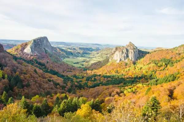Paysage d'automne en Auvergne, avec des volcans et des forêts aux couleurs vives. Idéal pour savoir où aller en Auvergne l'été, mais magnifique aussi en automne.