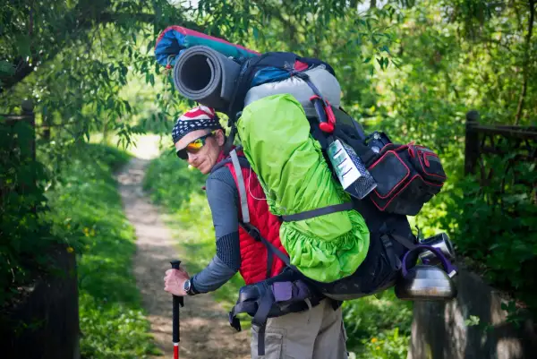 Randonneur avec un sac de trek chargé, prêt à affronter le poids de son aventure.