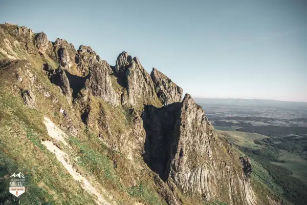 Le cirque de la fontaine salée, un paysage de montagnes escarpées et verdoyantes sous un ciel clair.