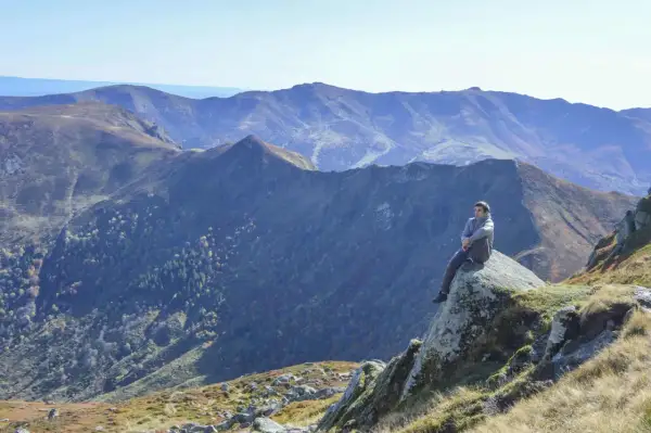 Un homme contemple les paysages grandioses du Cantal, un aperçu de ce que réservent les plus belles randonnées dans le Cantal.