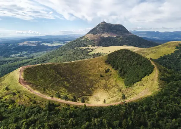 Vue aérienne du cratère du Pariou, un volcan endormi en Auvergne, avec le Puy de Dôme en arrière-plan.